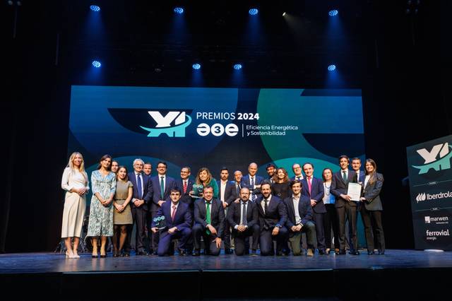 Un grupo de personas posa en un escenario durante una ceremonia de entrega de premios con un fondo que contiene logos y el texto 'PREMIOS 2024 Eficiencia Energética y Sostenibilidad'.