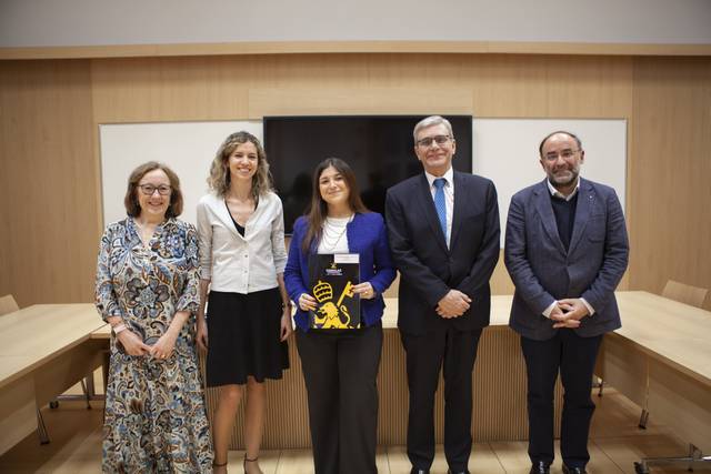 Un grupo de cinco personas posando juntas en una sala de conferencias.