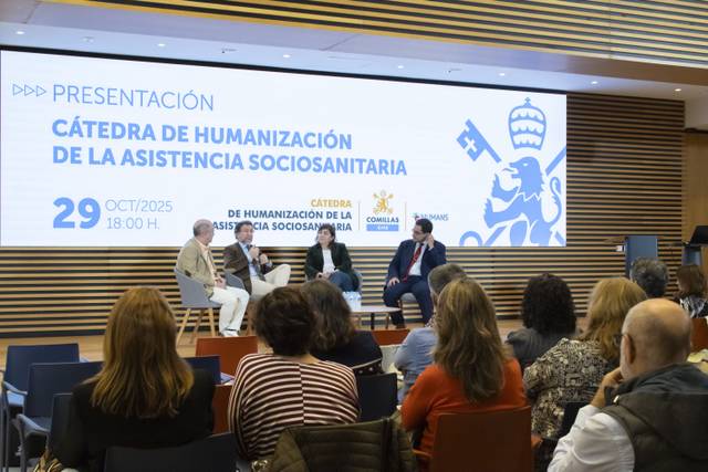 Una presentación sobre la cátedra de humanización de la asistencia sociosanitaria en un auditorio con varios asistentes.