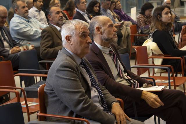 Una conferencia con un grupo de personas sentadas en un auditorio escuchando atentamente.