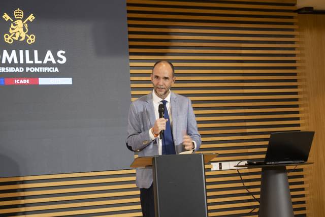 Un hombre habla frente a un micrófono en un evento académico.