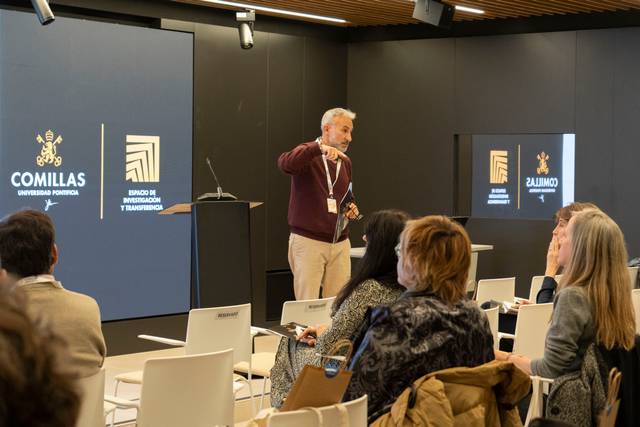 Un hombre está presentando en una conferencia ante un público sentado.