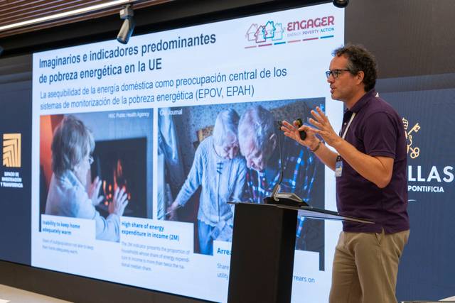 Un ponente expone sobre la pobreza energética en la Unión Europea, mostrando gráficas relacionadas en una presentación.