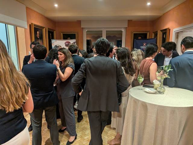 Un grupo de personas conversando en un evento social elegante.