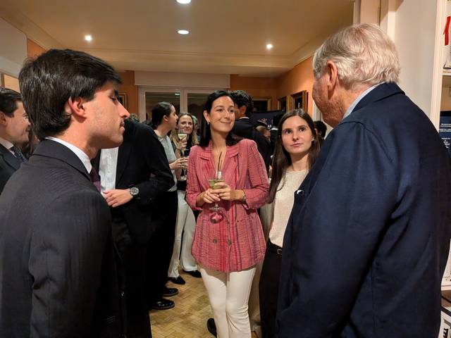 Un grupo de personas conversando en un evento social elegante.