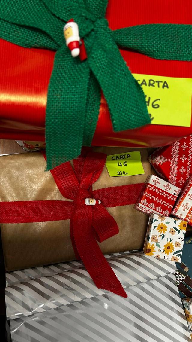 Una colección de regalos envueltos con cintas de colores y etiquetas.