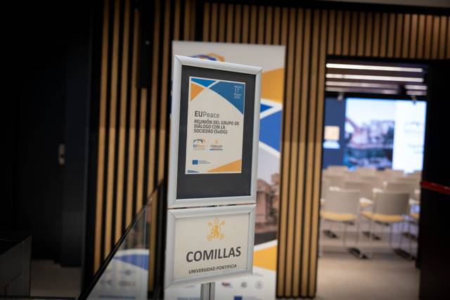 La imagen muestra un cartel en un evento sobre la sociedad civil, ubicado en la universidad.