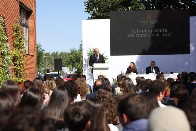 Un acto de apertura del curso académico 2026-2027 en una institución educativa con un orador en el podio frente a un público atento.