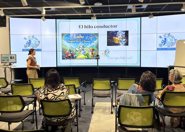 Una presentación que muestra un libro titulado 'Lulu: Magical World of Sounds' en una sala con varias personas observando.