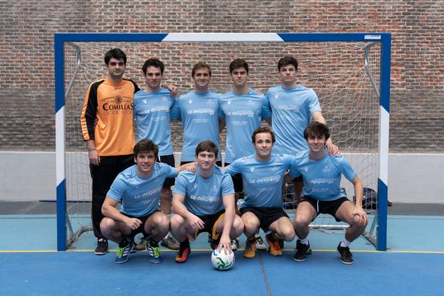 Un grupo de jóvenes posando en una cancha de fútbol sala.