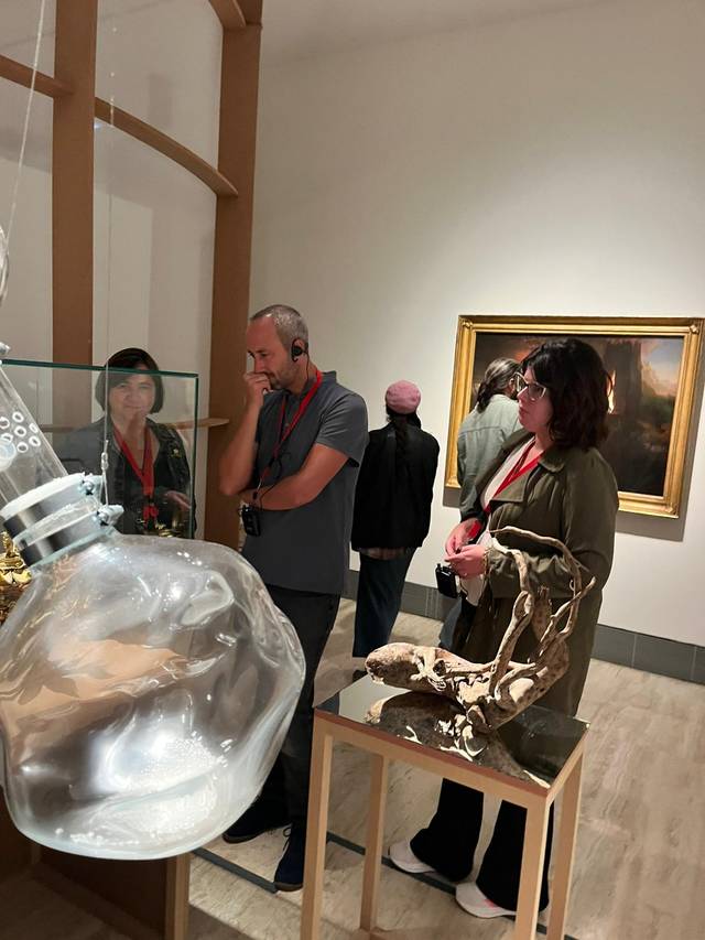 Un grupo de personas observa una obra de arte en un museo.