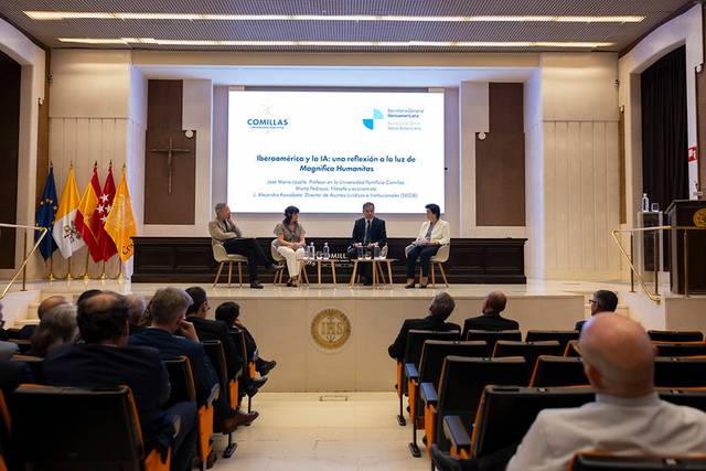 Un panel de discusión sobre bioconstrucción y su relación con la luz, en un auditorio con público asistente.