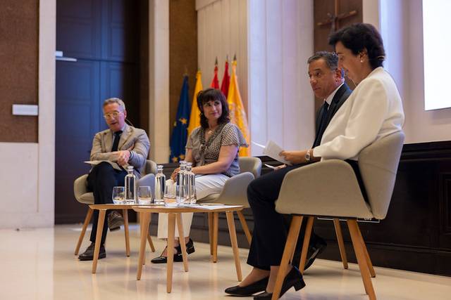 Un grupo de personas discutiendo en una mesa durante un evento formal.
