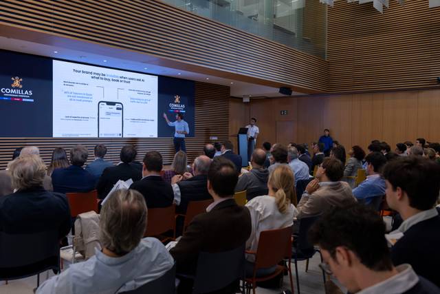 Una presentación en una sala con un ponente hablando frente a una audiencia.