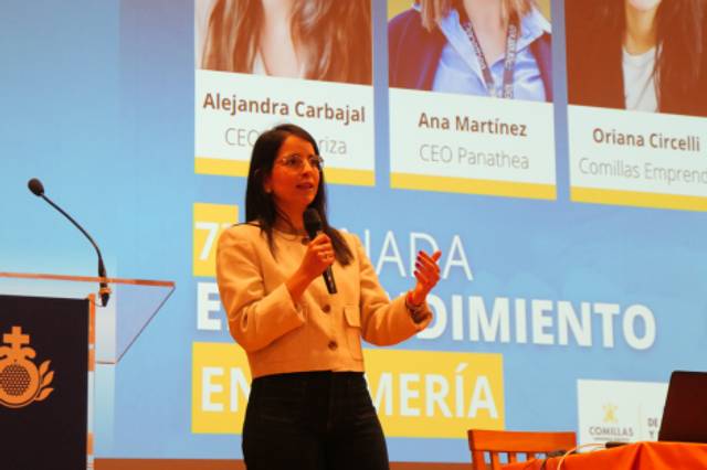 Una mujer de pie presenta en un evento sobre emprendimiento en enfermería.