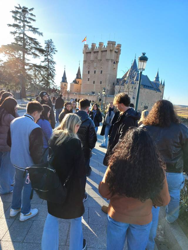 Grupo de personas visitando un castillo antiguo en un día soleado.