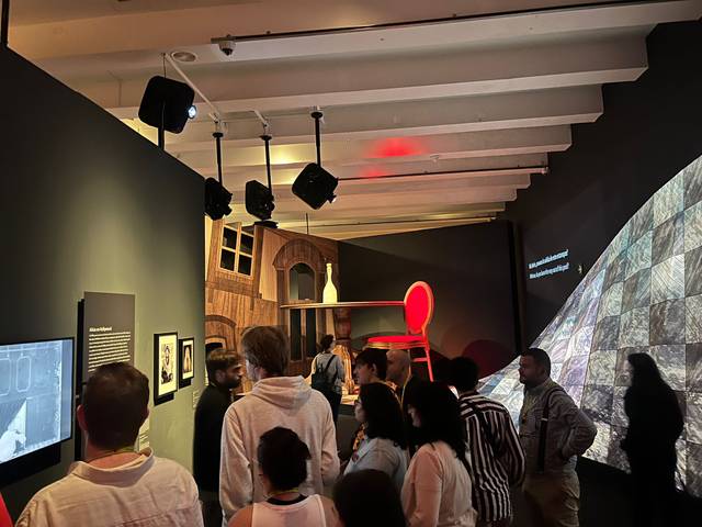 Un grupo de personas observa una instalación artística en una galería.