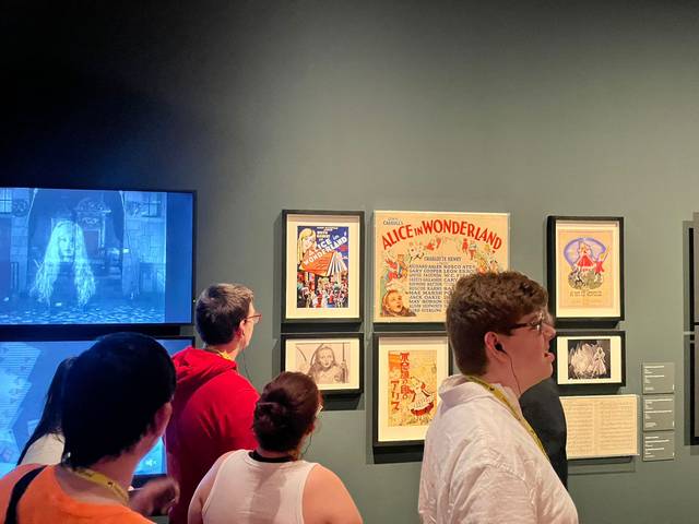 Un grupo de personas observa una exposición relacionada con 'Alicia en el País de las Maravillas'.
