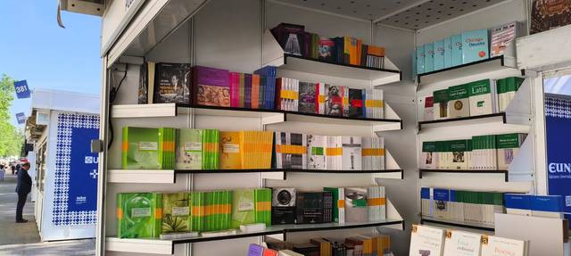 Una estantería de libros exhibida en un puesto de venta al aire libre.