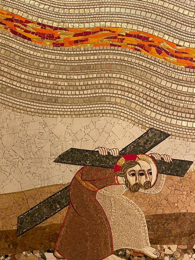 La imagen muestra a una figura que carga una cruz en un entorno abstracto y colorido.