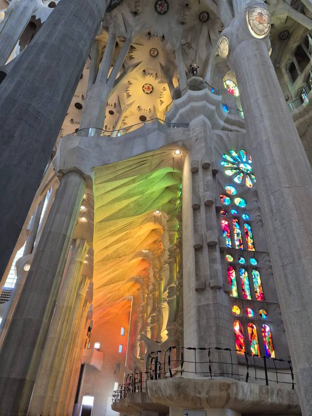 Interior de la Sagrada Familia, iluminado por colores vibrantes a través de las vidrieras.
