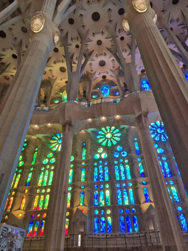 La imagen muestra el interior de una catedral con coloridos vitrales que reflejan la luz de manera impresionante.