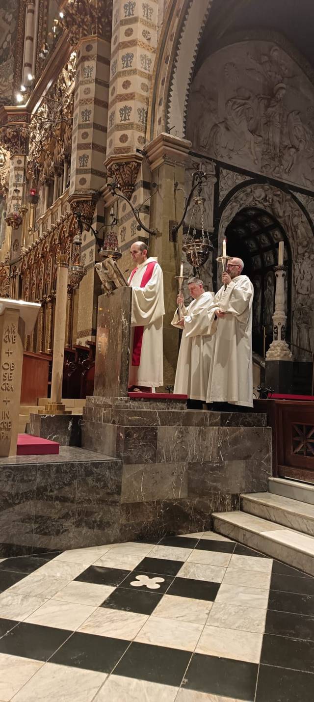 Un grupo de clérigos en una ceremonia religiosa dentro de una iglesia ornamentada.