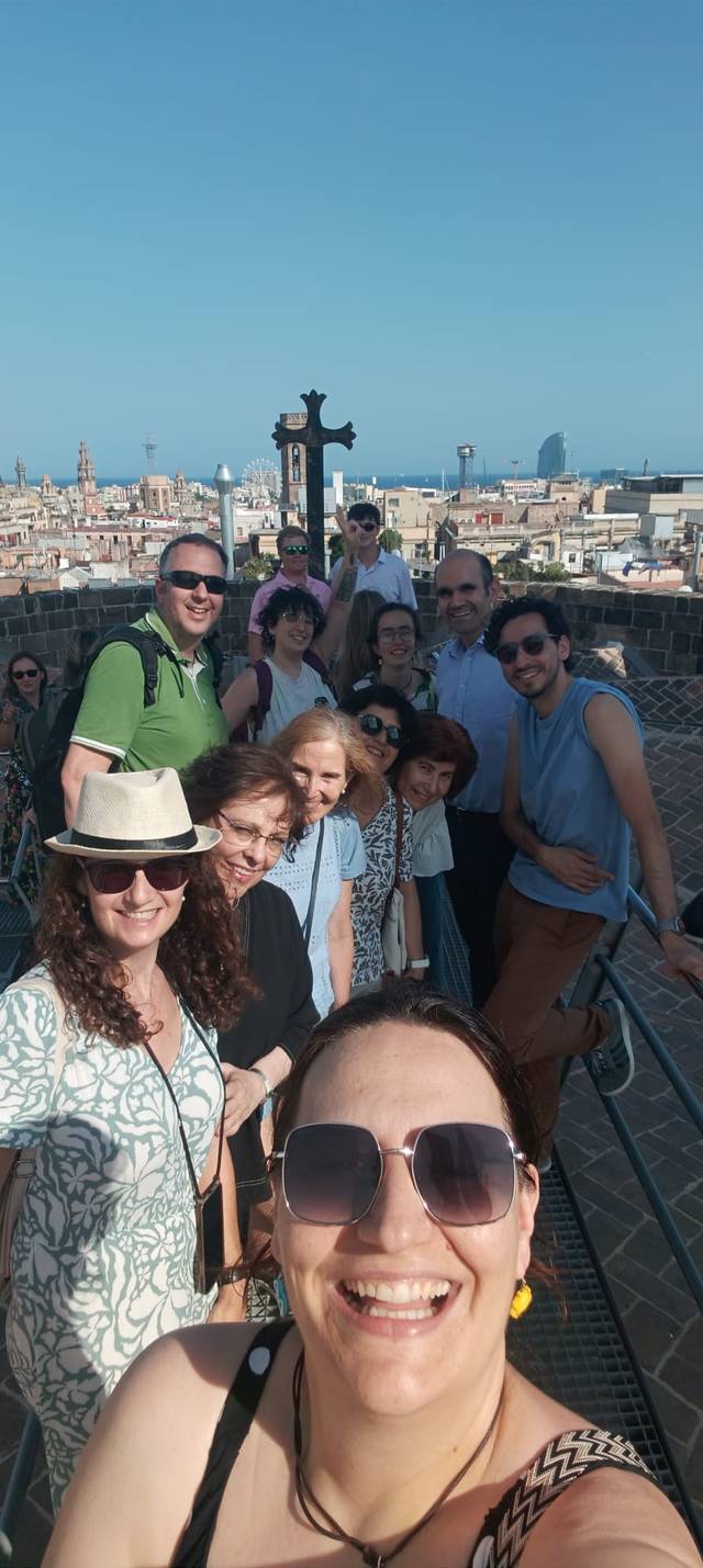 Un grupo de personas sonríe en una selfie con la ciudad de fondo.