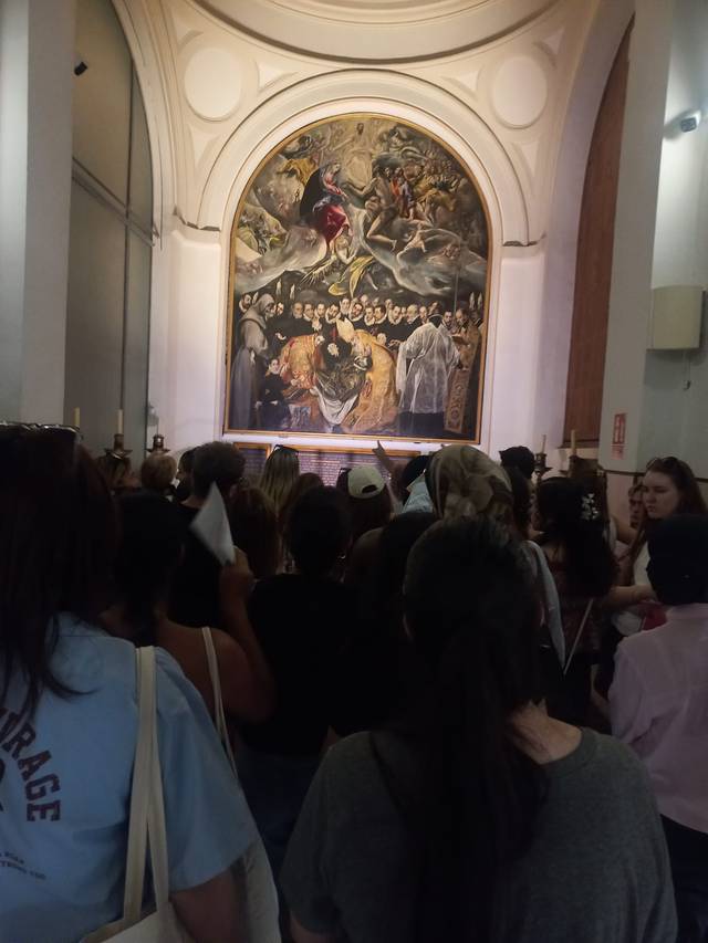 Un grupo de personas observa una obra de arte en una galería.