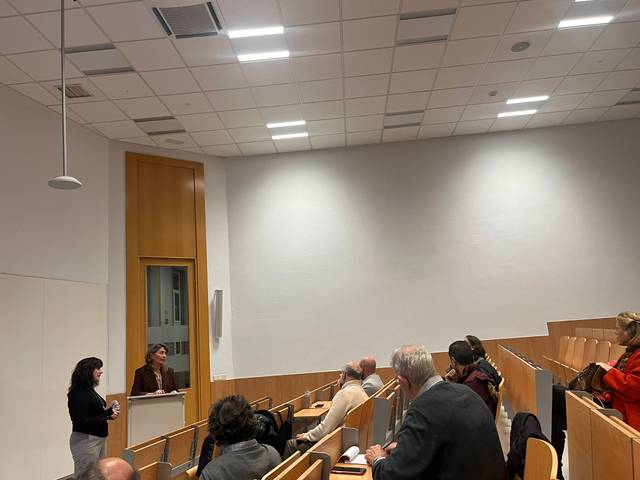Una presentación en un aula con un grupo de personas escuchando atentamente a dos oradoras.