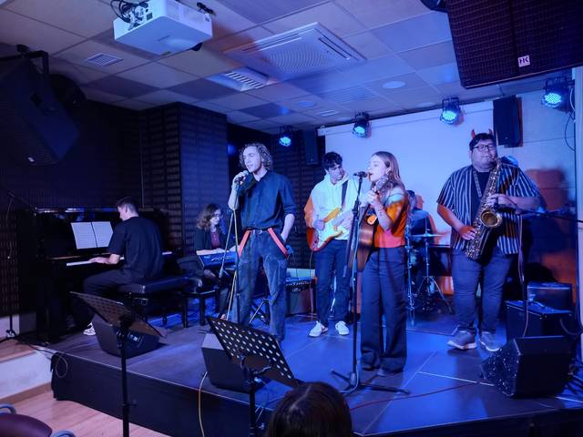 Un grupo de músicos actuando en un escenario con instrumentos variados.