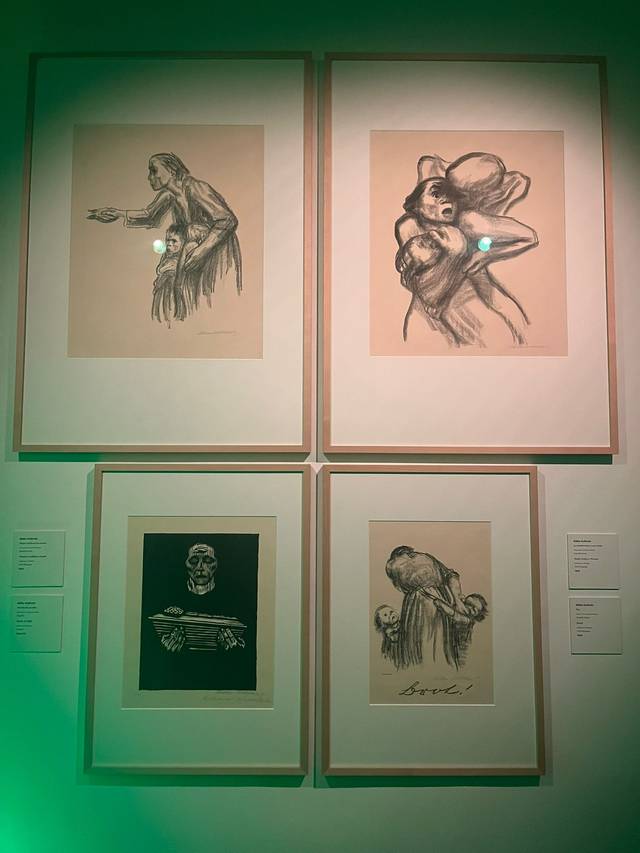 La imagen muestra cuatro dibujos enmarcados en una pared, con variados temas y estilos artísticos.