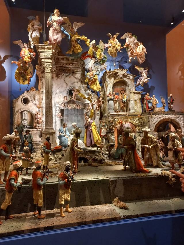 Una escena de un belén tradicional con figuras elaboradas y un fondo arquitectónico detallado.