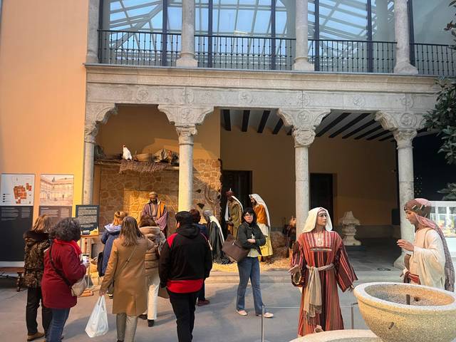 Un grupo de personas observa vestigios históricos en un museo con figuras vestidas con atuendos tradicionales.