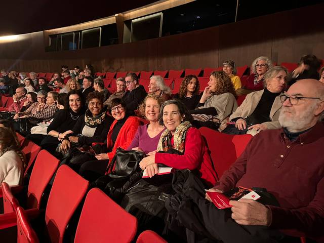Un grupo de personas sentadas en un teatro, listas para disfrutar de una obra.