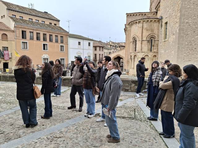 Un grupo de personas observa un edificio histórico en una plaza.