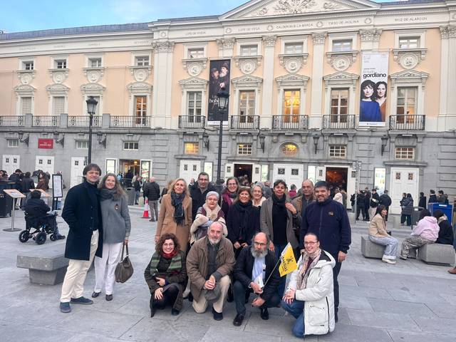 Un grupo de personas posando frente a un edificio emblemático en la ciudad.
