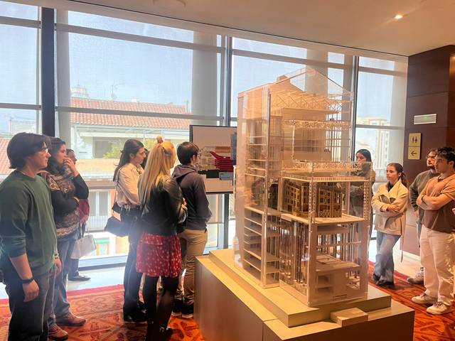 Un grupo de personas observa un modelo arquitectónico en una exposición.