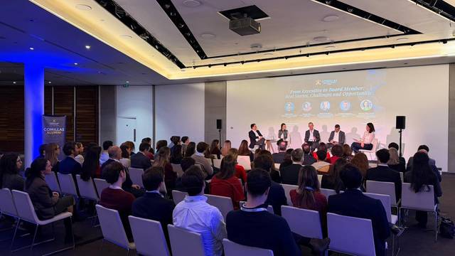 Un panel de discusión con varios expertos mientras una audiencia escucha atentamente.