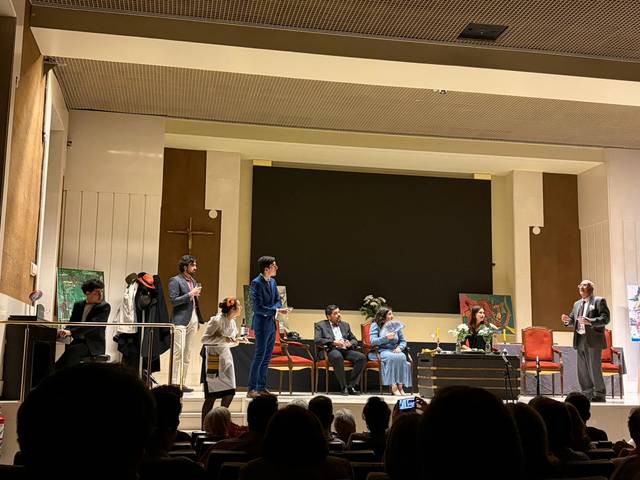 Un grupo de personas en un escenario, participando en una representación teatral.