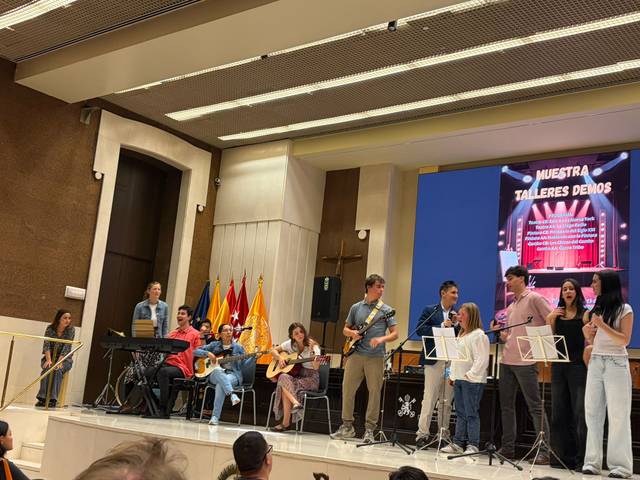 Grupo de personas realizando una presentación musical en un escenario.