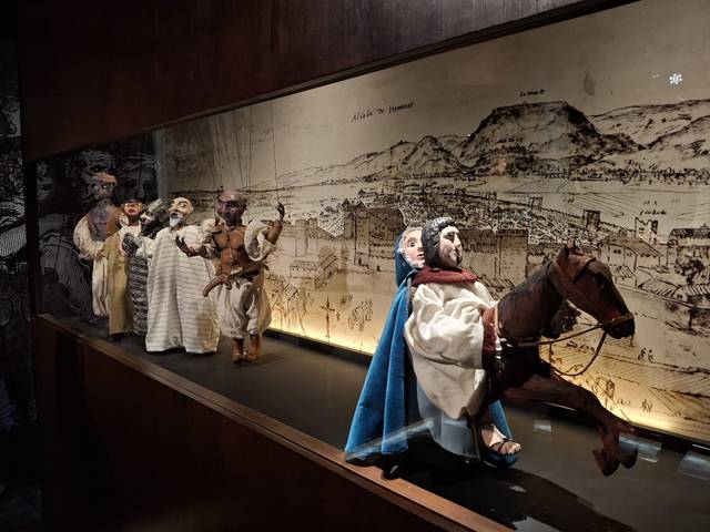 Una vitrina exhibe títeres tradicionales que representan personajes y escenas históricas.