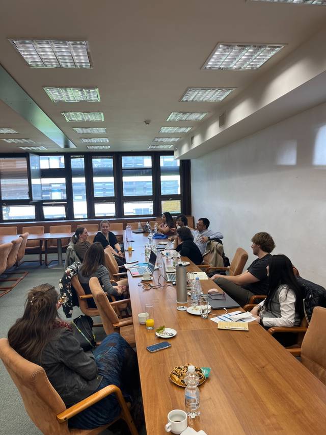 Un grupo de personas se reúne alrededor de una mesa larga en una sala de conferencias.