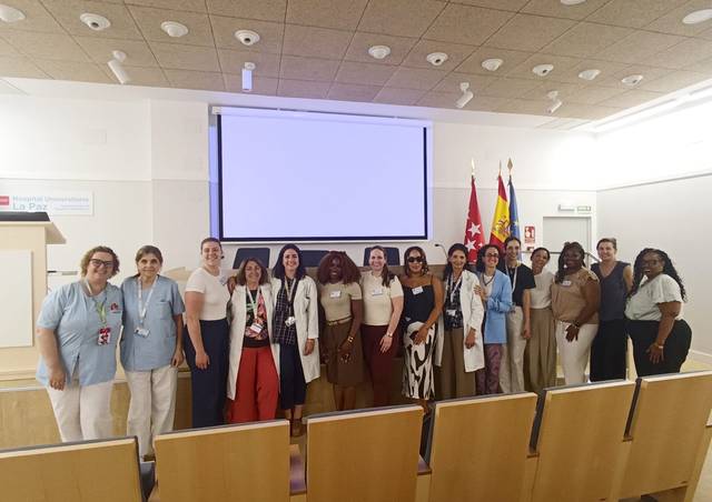 Un grupo diverso de mujeres posa juntas en un evento académico.