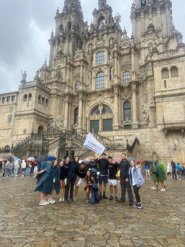 Grupo de personas frente a una impresionante catedral en un día nublado.