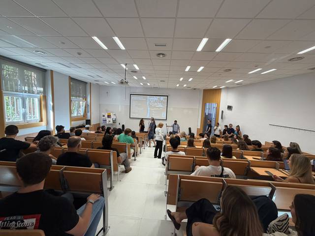 Un aula llena de estudiantes durante una presentación.