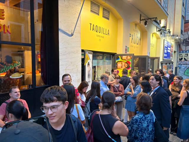 Una multitud de personas espera en la calle frente a un lugar llamado Taquilla.