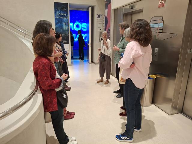 Un grupo de personas conversando en un vestíbulo moderno.