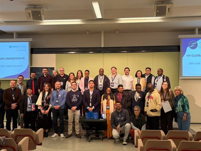 Un grupo diverso de personas se reúne en una conferencia, todos posando juntos para la foto.
