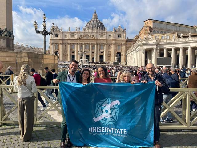 Un grupo de personas sostiene una bandera en la Plaza de San Pedro en el Vaticano.